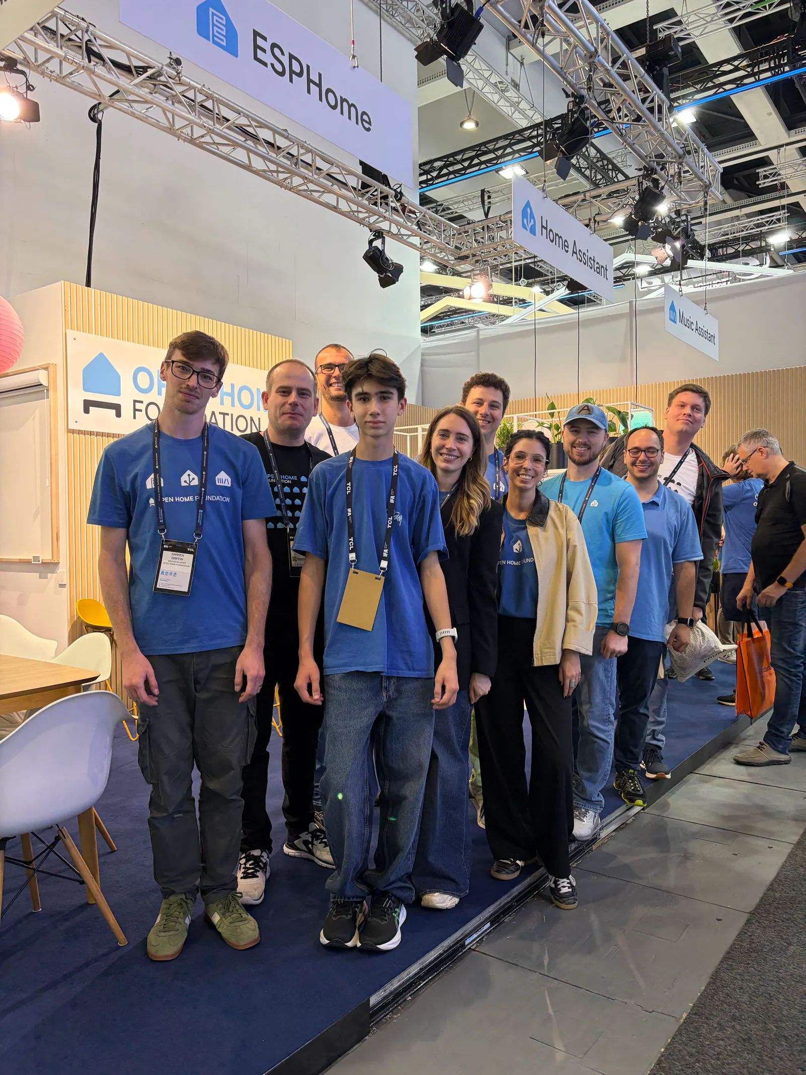 People gathered at the Open Home Foundation booth beneath ESPHome, Home Assistant and Music Assistant signs.