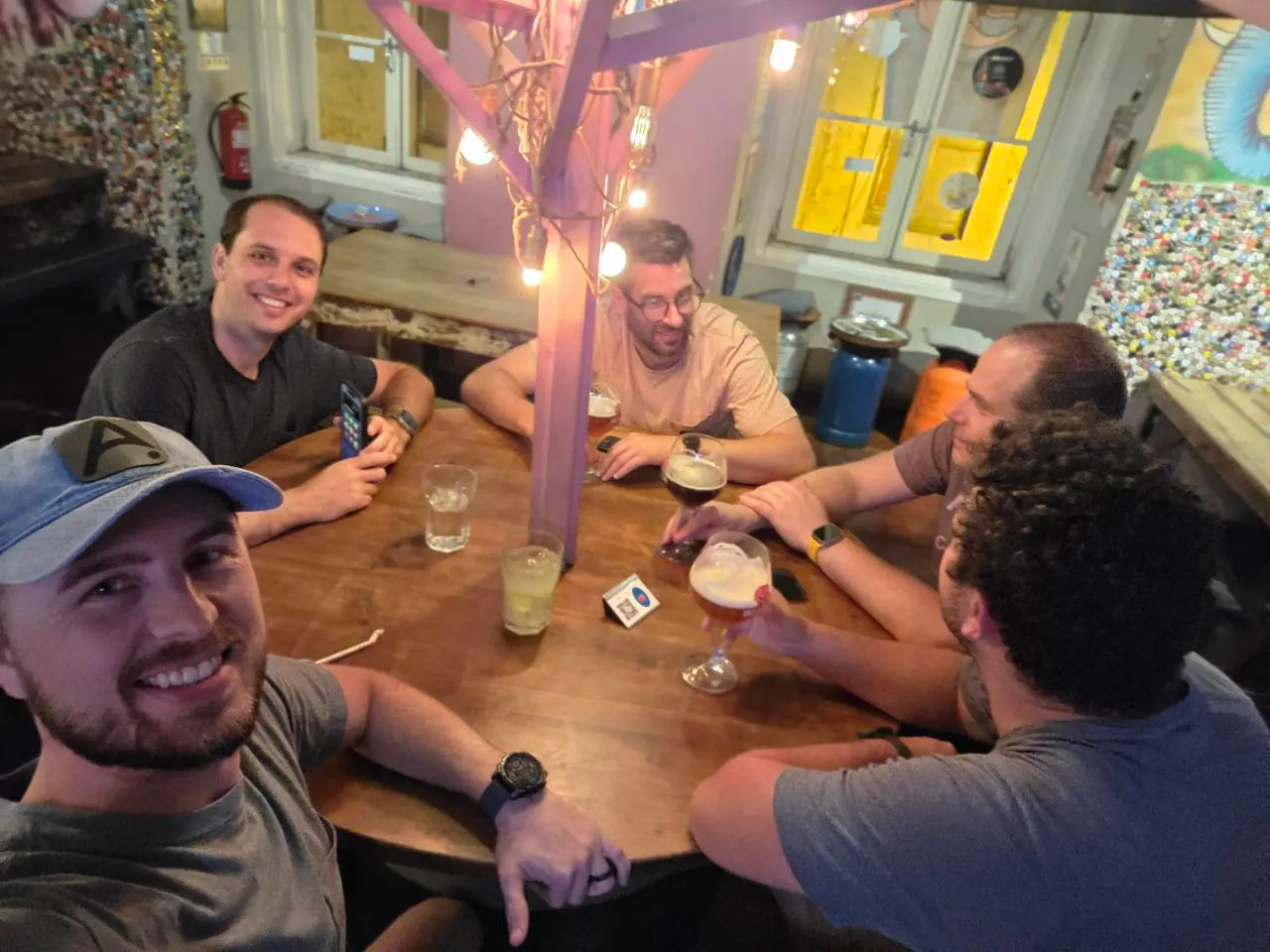 Five people sit around a wooden restaurant table in Lisbon.